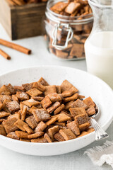 A bowl of homemade keto cinnamon toast crunchy cereal served with fresh milk.