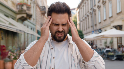 Unhappy young Caucasian man holding head business problem trouble city outdoors street frown disappointed dissatisfied guy failure loss angry upset male businessman stressed crisis frustration worry
