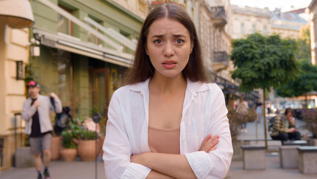 Caucasian european woman upset late time arms crossed showing hand watch angry displeased girl city street outside annoyed gen z wait lack of punctuality dissatisfied client delivery courier service