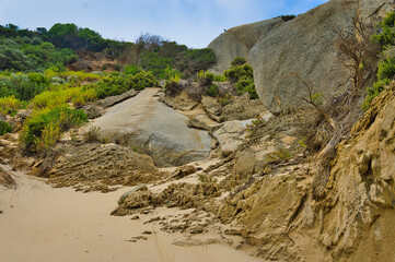 Huge granite boulders, sandy beach and flowering coastal vegetation at Oberon Bay, Wilsons Promontory, Victoria, Australia
