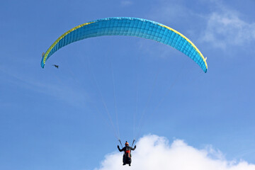 Paraglider flying in a blue sky	