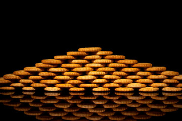 crackers stacked in the shape of a triangle with black background reflect