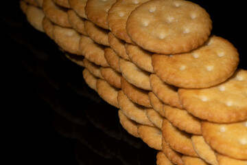 crackers stacked up to make a wall, close-up top view photo black background space for text