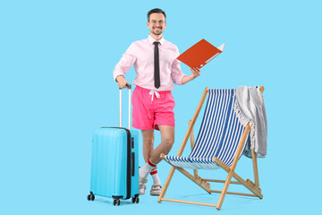 Funny businessman with folder and suitcase near deckchair on blue background