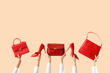 Female hands with stylish women's bags and high heels on beige background