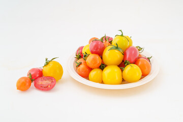 Fresh small persimmons of various colors on white background