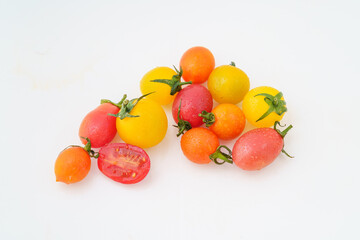 Fresh small persimmons of various colors on white background