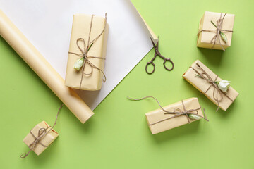 Gift boxes with wrapping paper, scissors and roses on green background. Woman's Day celebration