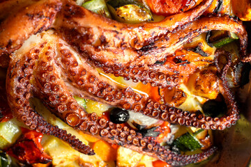 a whole freshly made octopus on griled vegetable bed in a restaurant in Rovinj Croatia