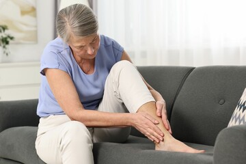 Arthritis symptoms. Woman suffering from pain in leg at home