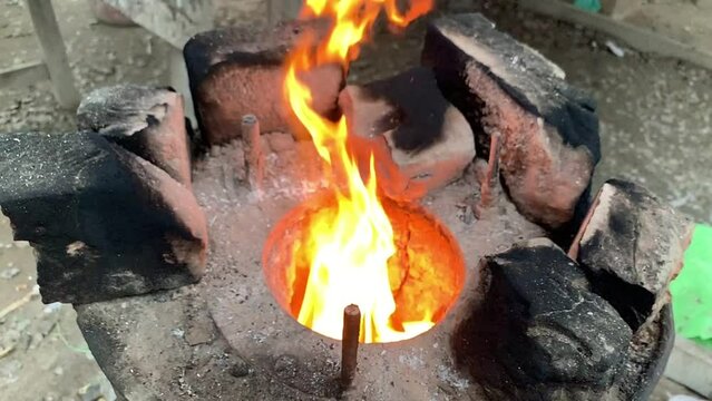Kindling firewood in the tandoor. Preparing the tandoor for baking bread. Barbecue outdoors. Slow motion video. Burning wood inside tandoor. Slow Motion Video