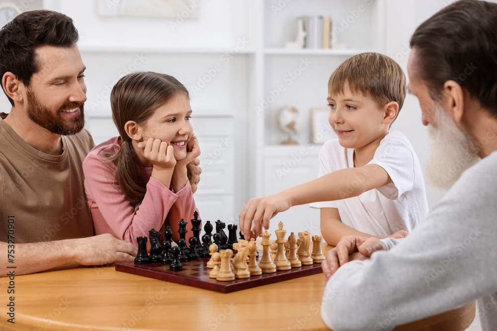 Canvas Prints Family playing chess together at table in room