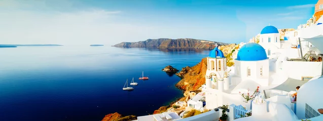 Fototapeten white church belfry, blue domes and volcano caldera with sea landscape, beautiful details of Santorini island, Greece, wide web banner format © neirfy