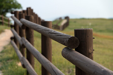 The wooden fence of the pasture on the hill