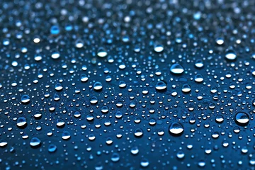 Fotobehang Detalles de gotas de lluvia sobre una superficie azul con desenfoque selectivo. © Jossfoto