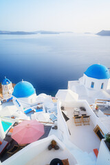 traditional greek village Oia of Santorini, with blue domes of churches and village street, Greece