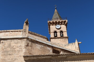 Fototapeta na wymiar Villena, Alicante, Spain, March 5, 2024: Bell tower and gargoyles of the Santiago Apostol church in Villena, Alicante, Spain