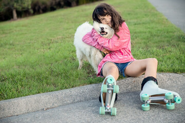 outdoor portrait of young caucasian girl with her pet dog, child owner with white fluffy japanese...