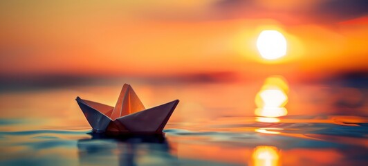 toy paper boat in the water during sunset