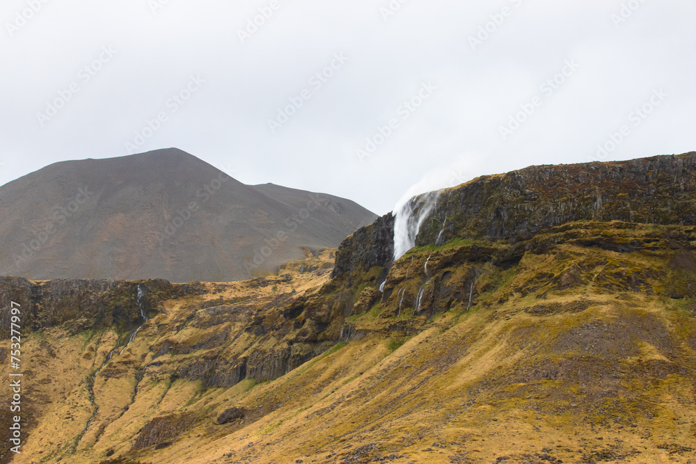 Wall mural A waterfall in Iceland in Scandinavia in northern Europe, in the land of fire and ice,