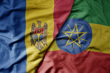 big waving national colorful flag of ethiopia and national flag of moldova .