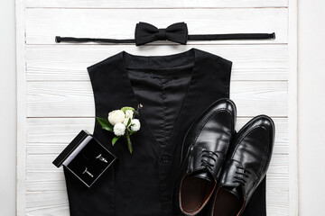 Vest with male shoes, bow tie and cufflinks on white wooden background. Prom outfit