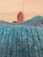 bright pink pedicure visible from under a blue azure sweater