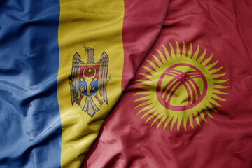 big waving national colorful flag of kyrgyzstan and national flag of moldova .