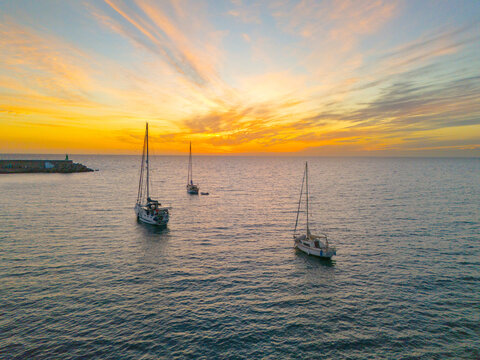 increible atardecer con barcos de fondo y cielo naranja en canarias