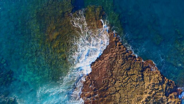 olas rompiendo sobre las rocas vistas desde el aire 