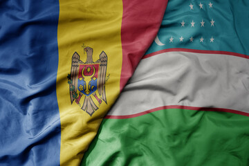 big waving national colorful flag of uzbekistan and national flag of moldova .