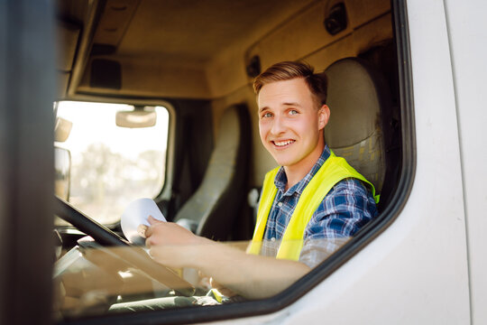 Truck driver job. Logistics - proud driver or forwarder on truck and trailer, on a transshipment point. Transportation service.