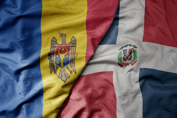 big waving national colorful flag of dominican republic and national flag of moldova .
