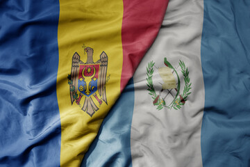 big waving national colorful flag of guatemala and national flag of moldova .