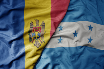 big waving national colorful flag of honduras and national flag of moldova .