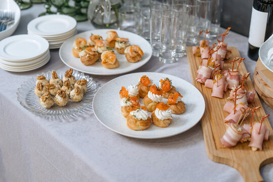 Snack cakes profiteroles with cream and salmon red fish.