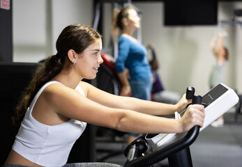 Caucasian woman training on exercise bike in gym