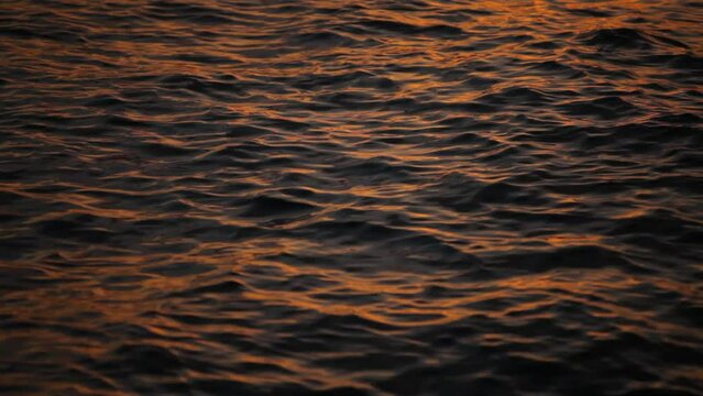 Sunset glow on rippling ocean water - close up