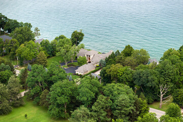 American dream homes on Ontario lakeshore as example of real estate development in US suburbs. View from above of waterfront residential houses in living area in Rochester, NY