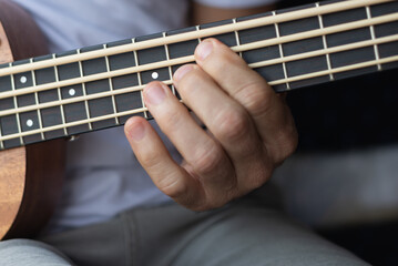 Detail of a hand playing a double bass with special strings.