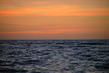 Dramatic red ocean waves at sunset with soft evening sea dark water