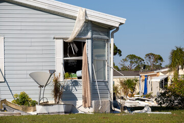 Heavily damaged by hurricane houses in Florida mobile home residential area. Consequences of...