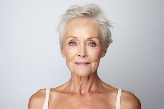 Portrait of a beautiful senior woman looking at the camera, against grey background