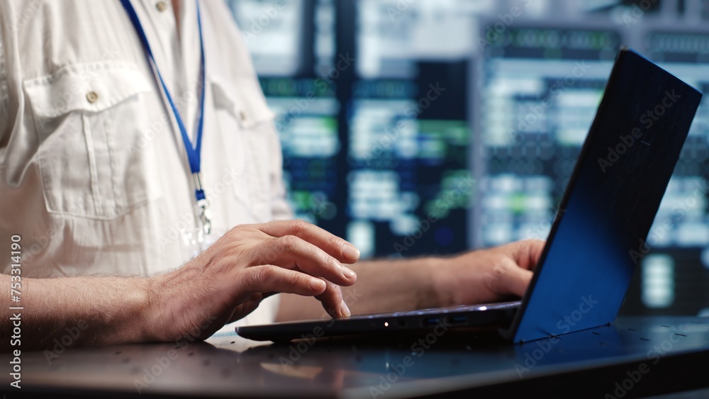 Poster certified it admin expertly managing data while navigating in industrial server room. trained comput