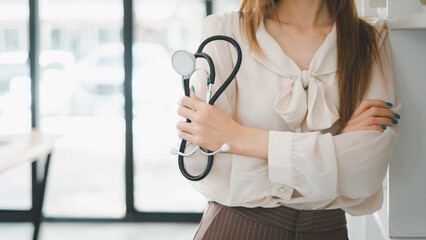 A confident healthcare professional stands poised in her clinic, stethoscope in hand, projecting a...