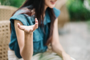 Close up of a woman hand gesturing during a conversation, with a blurred background emphasizing the...