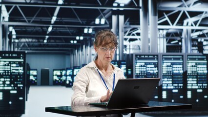 Certified employee working in server hub housing GPU dedicated supercomputers that can process AI...