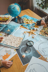 Idea for an activity with a child with sand and shells, learning geography