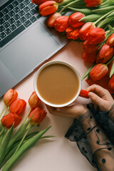 Cup of coffee, bouquet of red tulips and cake top view flat lay, festive background