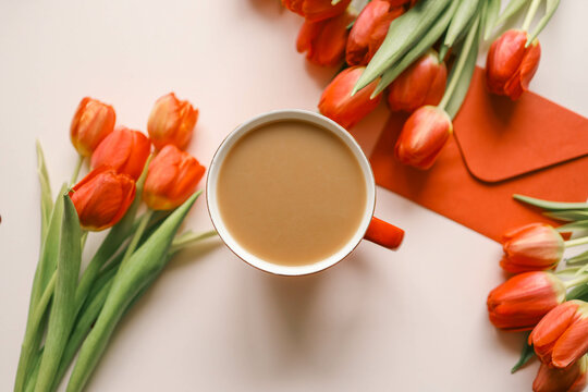 Cup of coffee, bouquet of red tulips and laptop top view flat lay, festive background